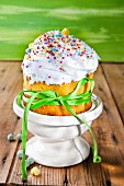 Cupcake mit Buttercreme, Zuckerperlen und grüner Schleife