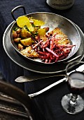 An escalope with beetroot and potato salad garnished with parsley and almonds
