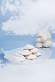 Meringues on a piece of paper and under a glass cloche