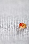 Molecular gastronomy: a droplet of jelly with chilli on a piece of coarse fabric