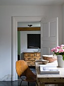 Vintage, 50s shell chair (Medea chair), wooden bowls and vase of roses on table and antique, French chest of drawers in background