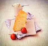 Two slices of sponge cake with cream and strawberries