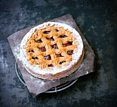 Linzertorte (nut and jam layer cake) with icing sugar on a piece of baking paper