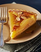 A slice of pear tart with slivered almonds