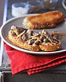 A slice of bread topped with morel mushrooms and onions
