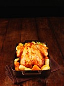 Roast chicken with root vegetables in a roasting tin