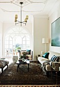 Fifties-style interior with stucco ceiling and sofa set in contrasting light and dark shades; arched door in background