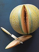 A cantaloupe melon with a slice cut out