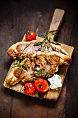 Lamb chops with rosemary and tomatoes on a chopping board