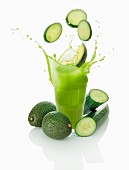 Cucumber slices falling into a vegetables smoothie