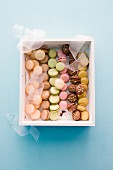 Various colourful macaroons in a gift box (seen from above)