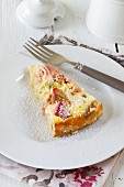 Slice of rhubarb cake with a sour cream topping on a plate