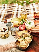 An autumnal picnic with cheese rolls, apples, apple juice, egg salad and biscuits