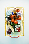 Vegetables and other groceries in a shopping basket