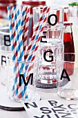 Drinking glasses with black alphabet stickers and drinking straws