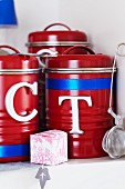 Red storage containers decorated with metal letters