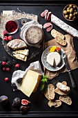 An arrangement of cheese also featuring fruit, salami, bread, olives and wine