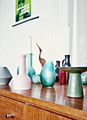Danish candlesticks and collection of small ceramic vases from flea-market on 60s, retro sideboard