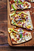 Unleavened bread with red onions, spring onions, sweetcorn, bacon and fontina cheese