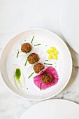 Falafel on slices of radish (seen from above)
