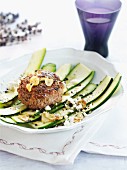 A minced meat steak with garlic on a courgette salad