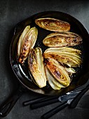 Fried chicory halves in a pan