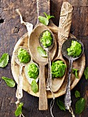 Mushy peas with mint on spoons