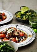 Stuffed pork rolls on a tomato and olive medley served with chard