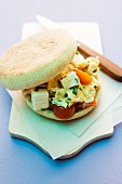 Scrambled eggs, feta and tomatoes in an English muffin