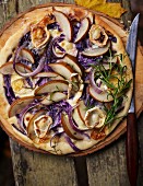 An autumnal pizza with pears, goat's cheese and red onions