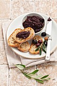 Tapenade with slices of bread and a sprig of olives