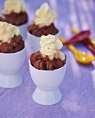 Salty chocolate cream with pear compote and cream in egg cups