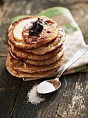 A stack of blueberry pancakes with sugar and blueberries