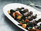 Game skewers with spinach and sweet potatoes