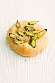 Focaccia with green asparagus and Parmesan on a wooden surface