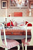 Nostalgic dining area with lit candles and bowl of winter apples on dining table