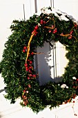 Advent wreath with red berries hanging on exterior door
