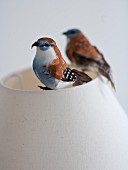 Deko Vogelfiguren auf Lampenschirm aus hellem Stoff