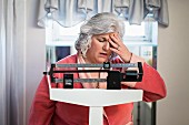 A worried woman standing on scales