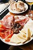An antipasti platter featuring salami, cheese, olives and fig chutney