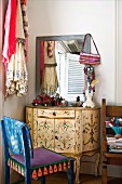 Vintage, Rococo-style dressing table and chair painted in ethnic patterns in corner of room
