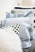 Row of patterned and plain scatter cushions on bench