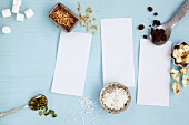 An arrangement of notepaper and baking ingredients (seen from above)