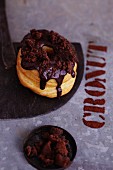 A croissant-doughnut with chocolate glaze and cookies