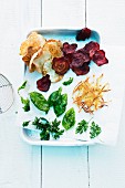 Fried herbs, fried vegetable chips and crispy potato lattice