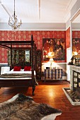Traditionelles Himmelbett mit gedrechselten Holzsäulen, an Wand Ornament Tapete mit rotem Hintergrund in ländlich traditionellem Schlafzimmer