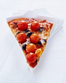 A slice of pizza with cherry tomatoes, olives and Parmesan