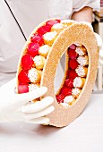 A confectioner creating a pièce montée wedding cake with profiteroles (France)