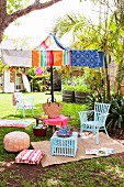 Casual picnic atmosphere in summery garden with colourful beach towels as parasol