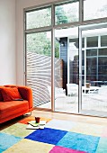 View from colourful lounge area into sunny courtyard of Australian beach house